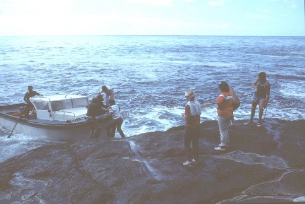 A launch coming alongside a rocky shore at Tristan.
