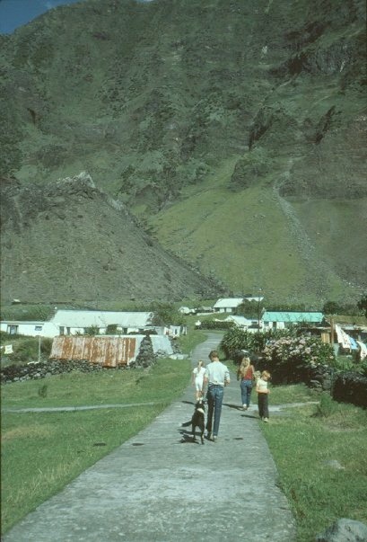 The family walking through the village with the peak behind.
